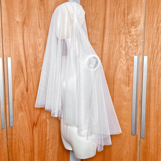Fingertip length juliet cap veil with a two-tier blusher over the face.