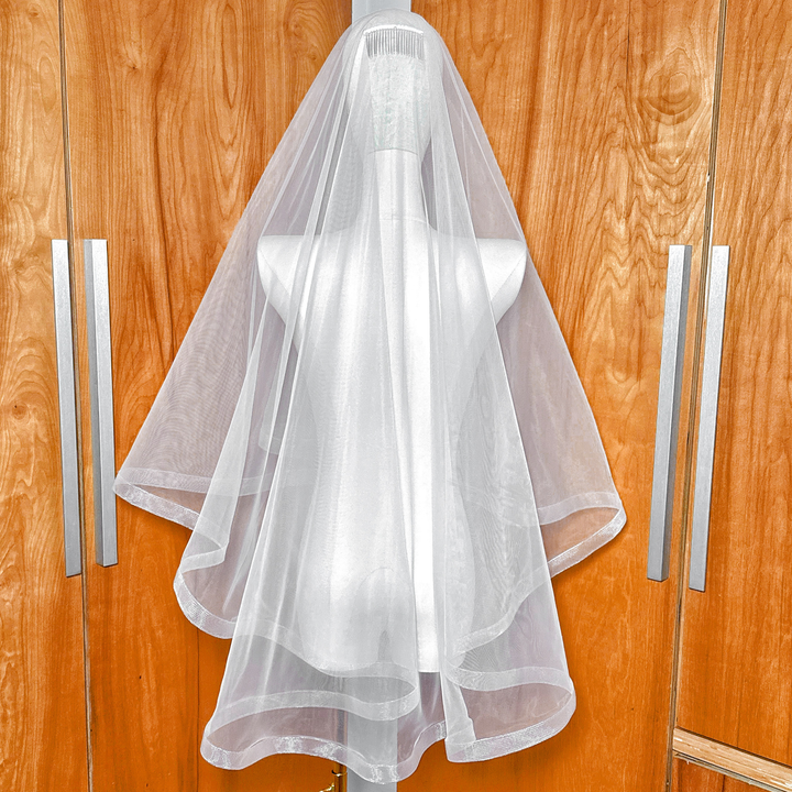 Rear view of a fingertip length 1 1/2" horsehair trim wedding veil with blusher on a mannequin.