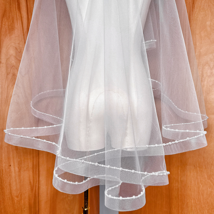 Fingertip style two-tier horsehair veil with a sophisticated pearl-trimmed border.