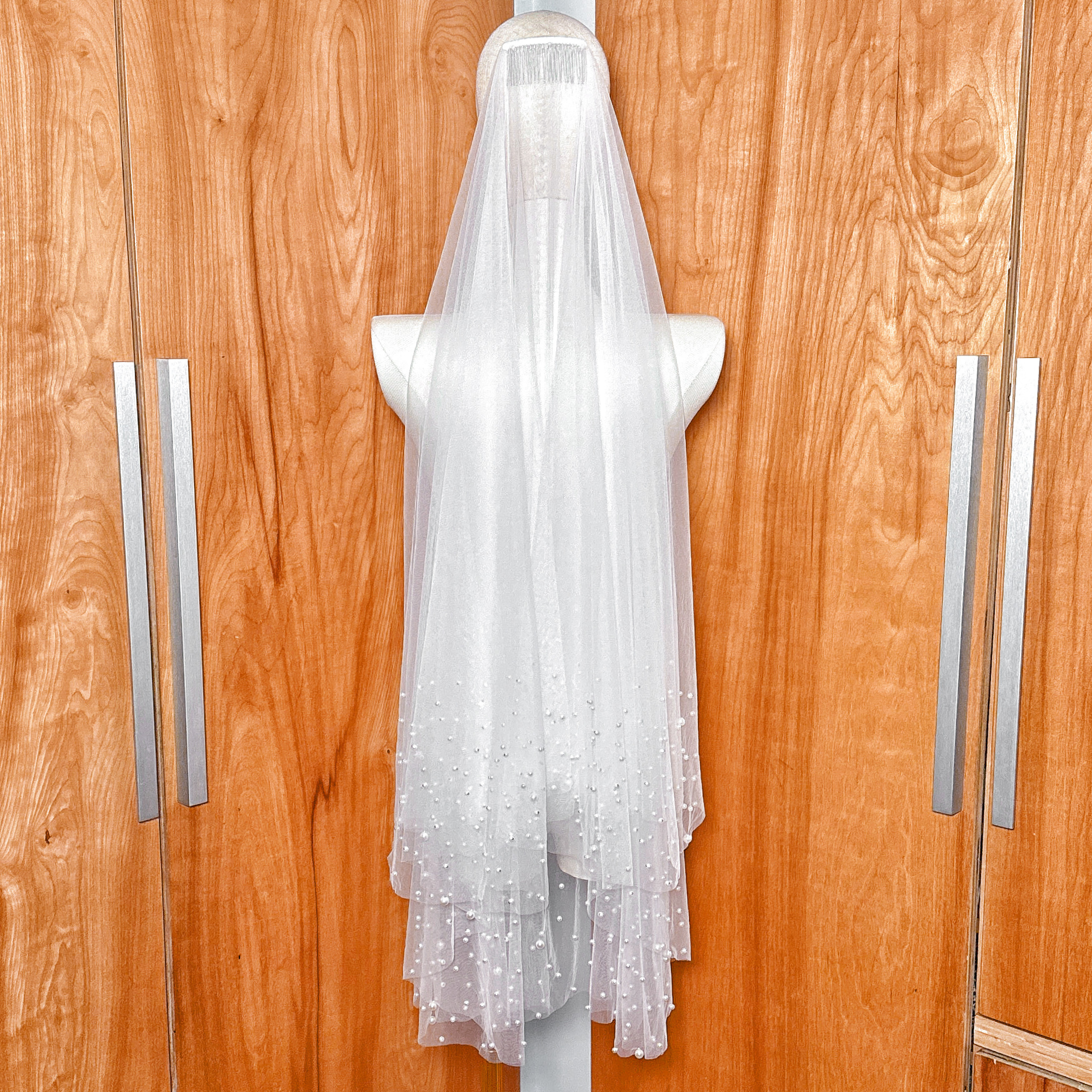 Close-up of the delicate soft tulle fabric on a two tier scattered pearl wedding veil.