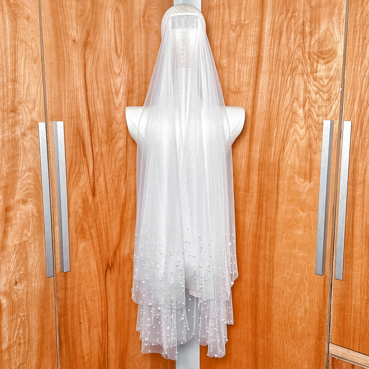 Close-up of the delicate soft tulle fabric on a two tier scattered pearl wedding veil.