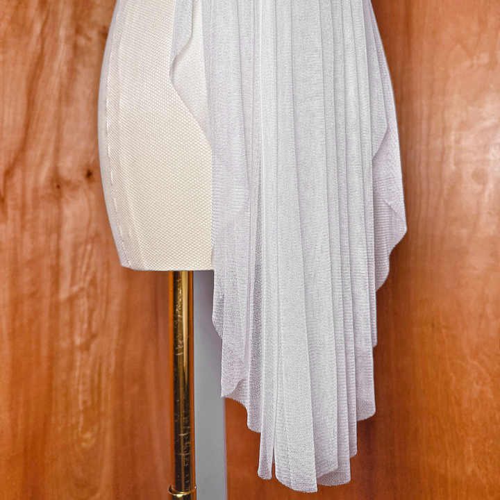 Detailed shot of the clean, finished edge on a fingertip-length silk tulle bridal veil.