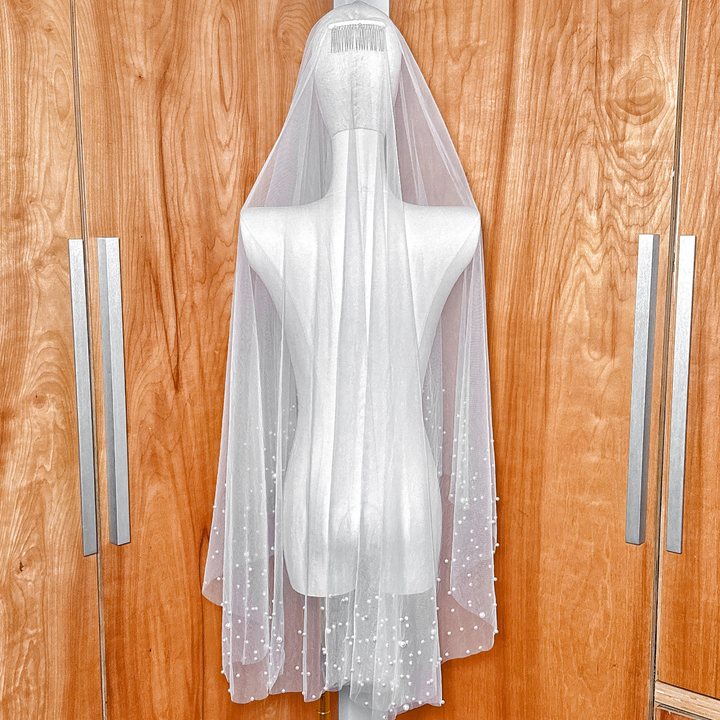 Back view of a fingertip length two tier scattered pearl wedding veil showing the layered tulle effect.