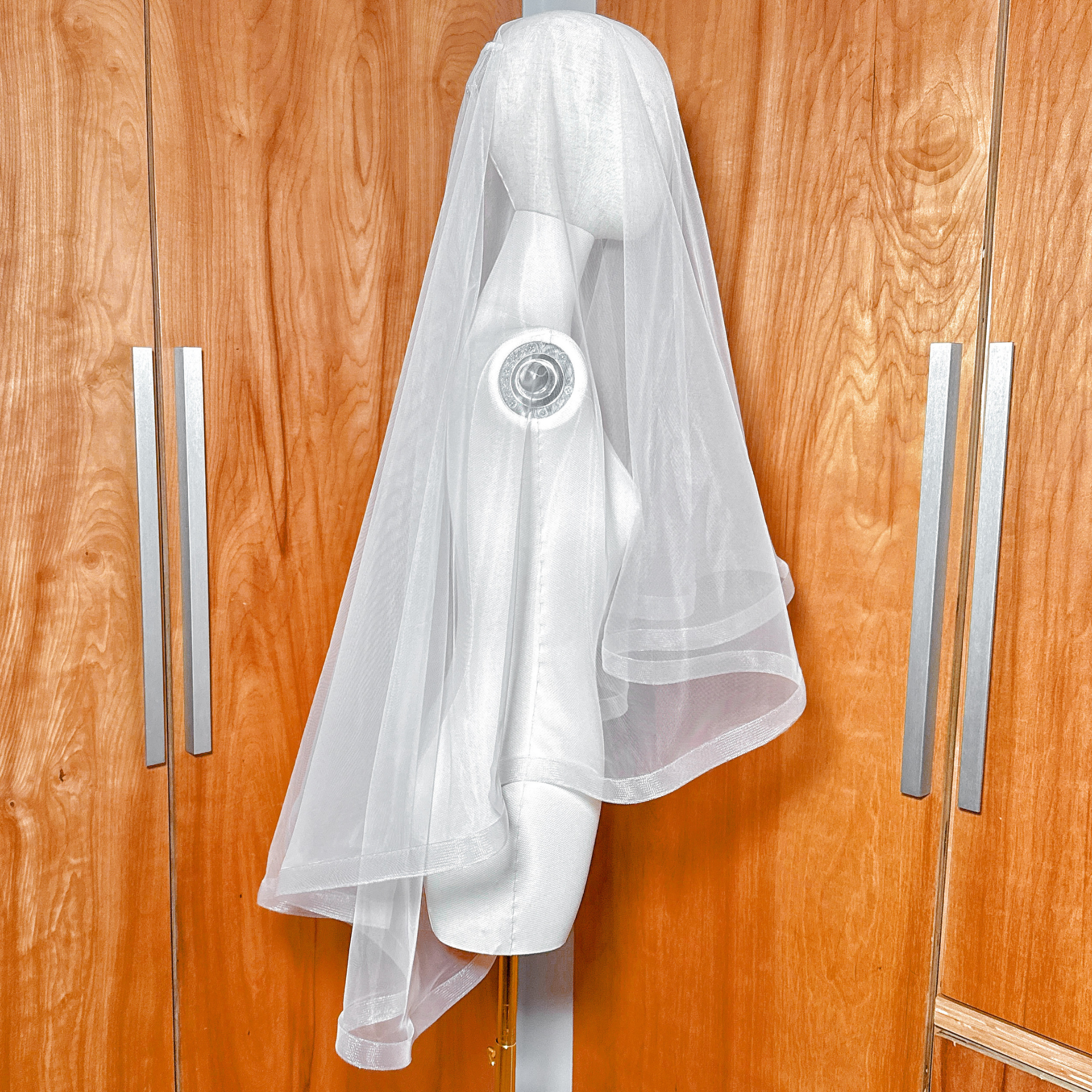 Side view of a 1 1/2" horsehair trim wedding veil with blusher on a mannequin showing the fingertip length.