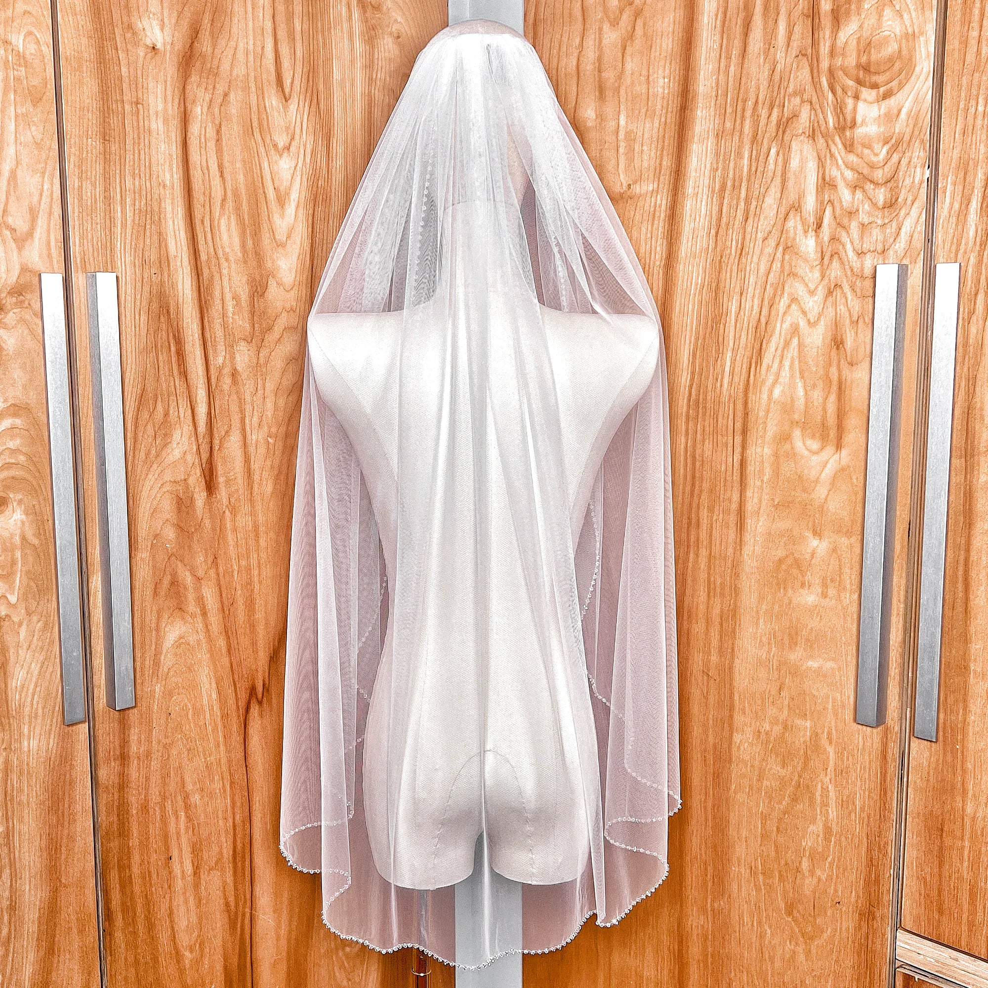 Back view of a fingertip length wedding veil with a crystal beaded edge.