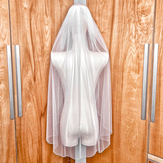 Back view of a fingertip length wedding veil with a crystal beaded edge.