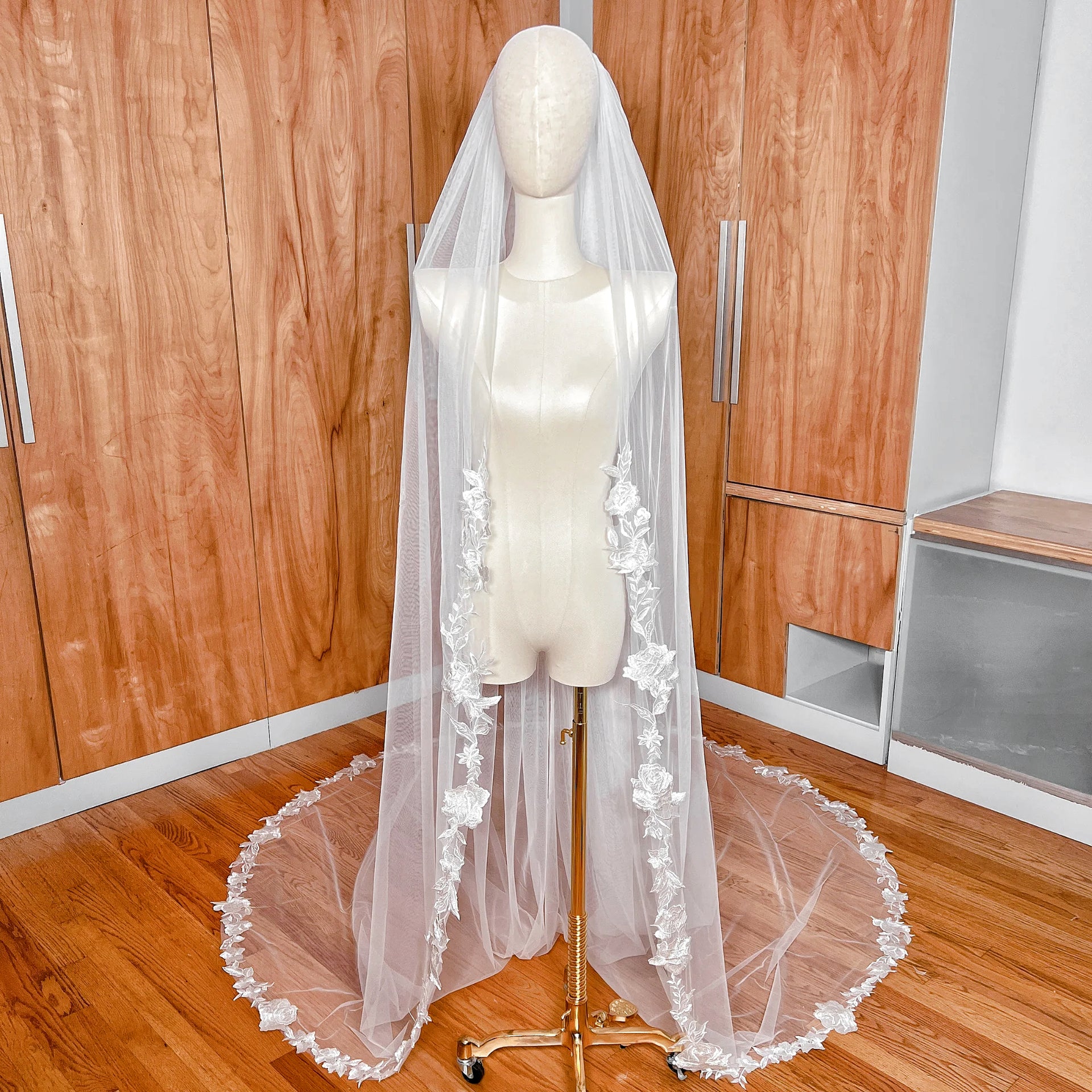 Cathedral length floral appliqué wedding veil displayed on a mannequin to show the full scale and flow.