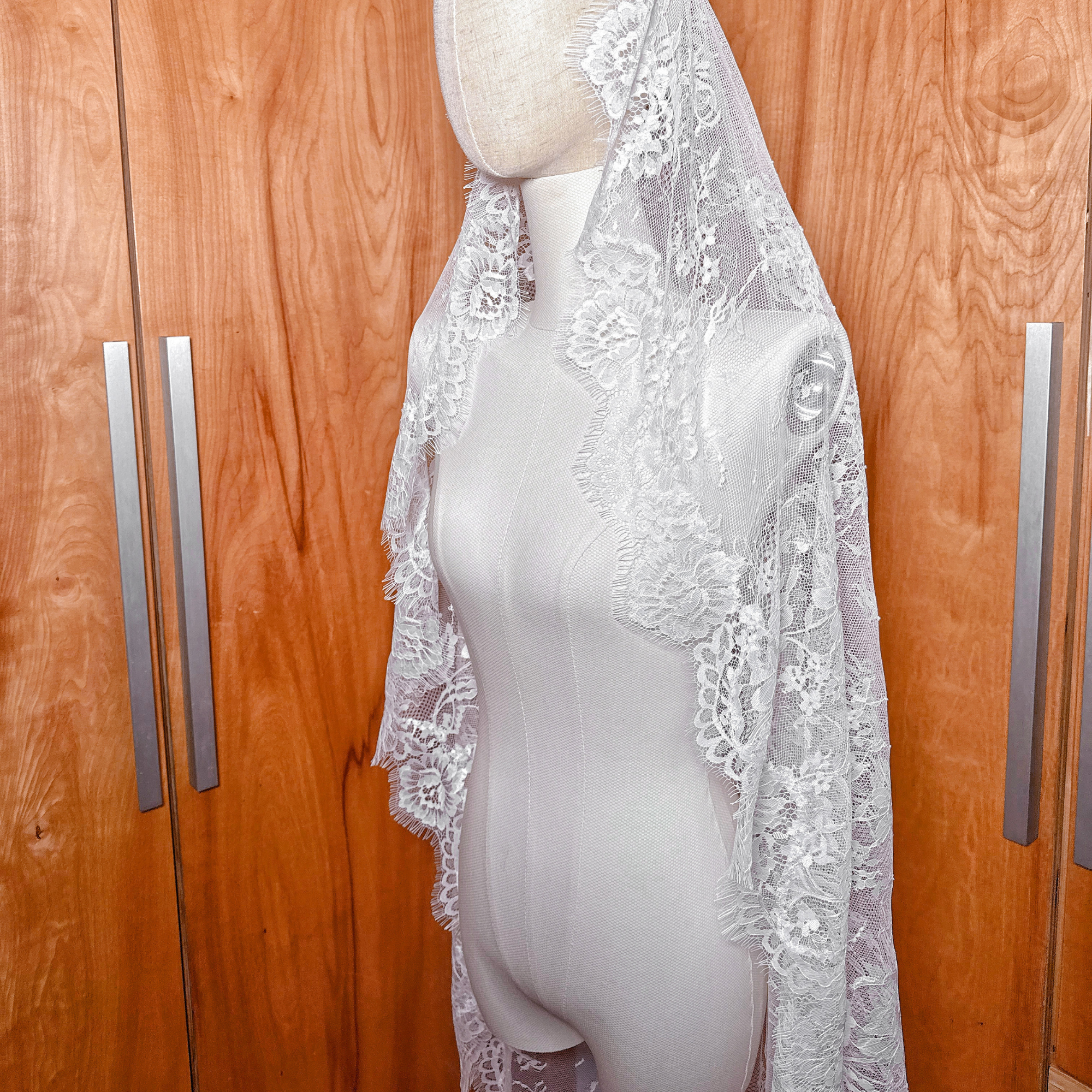 A waltz length full lace mantilla veil on a mannequin.
