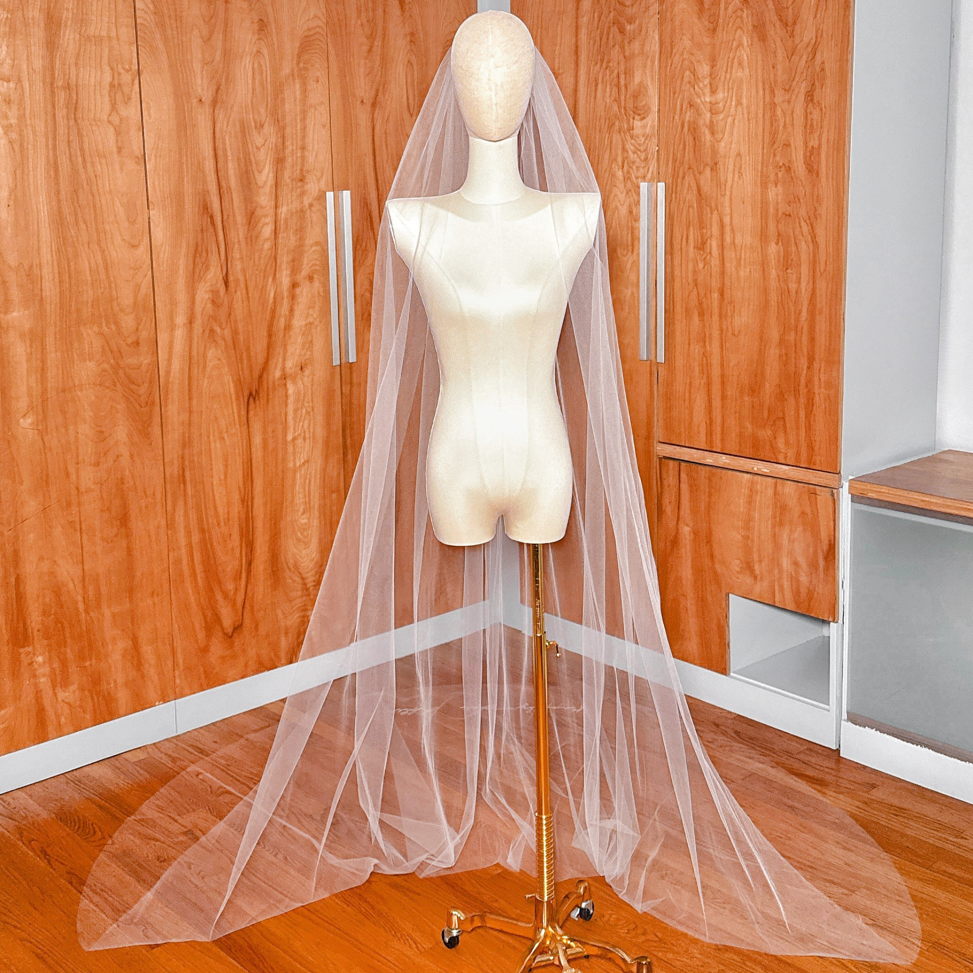 Bridal mannequin wearing the veil to showcase its drape and bottom-edge design.