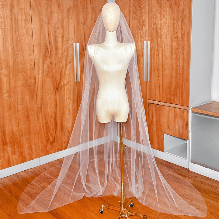 Bridal mannequin wearing the veil to showcase its drape and bottom-edge design.