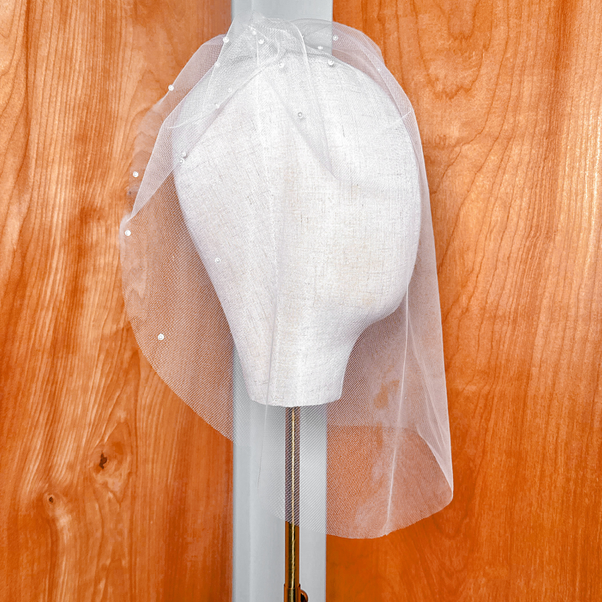 Top-down angle of a vintage style pearl birdcage wedding veil covering the face area.