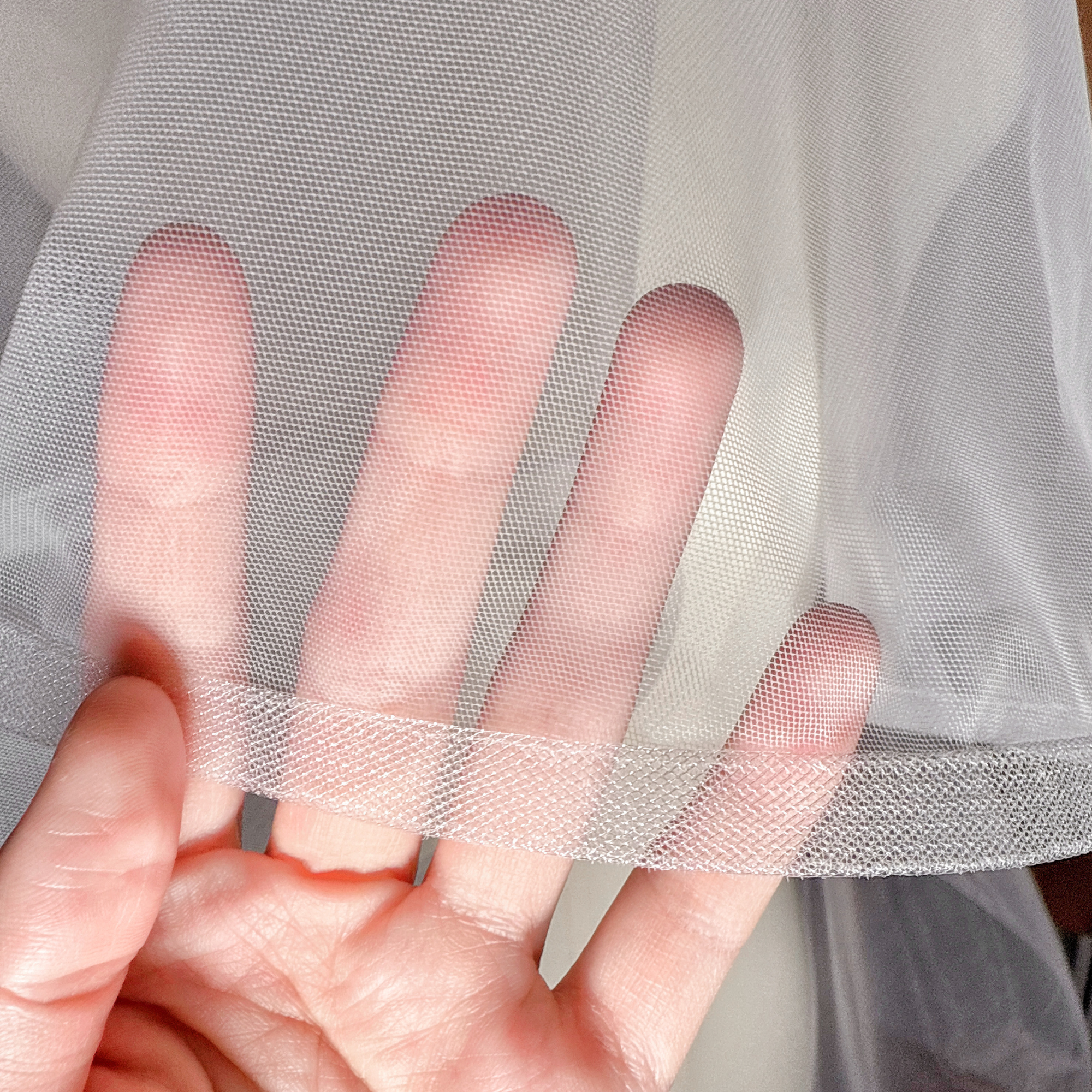 Close-up of the 1/2" horsehair trim on a two-tier cathedral wedding veil with blusher.