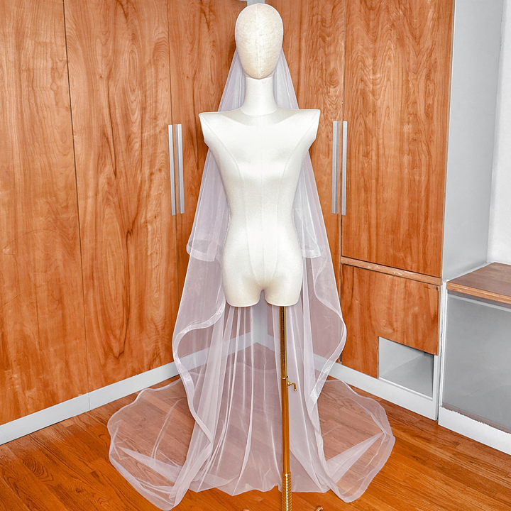 1 1/2" horsehair trim wedding veil with blusher in cathedral length displayed on a bridal mannequin.