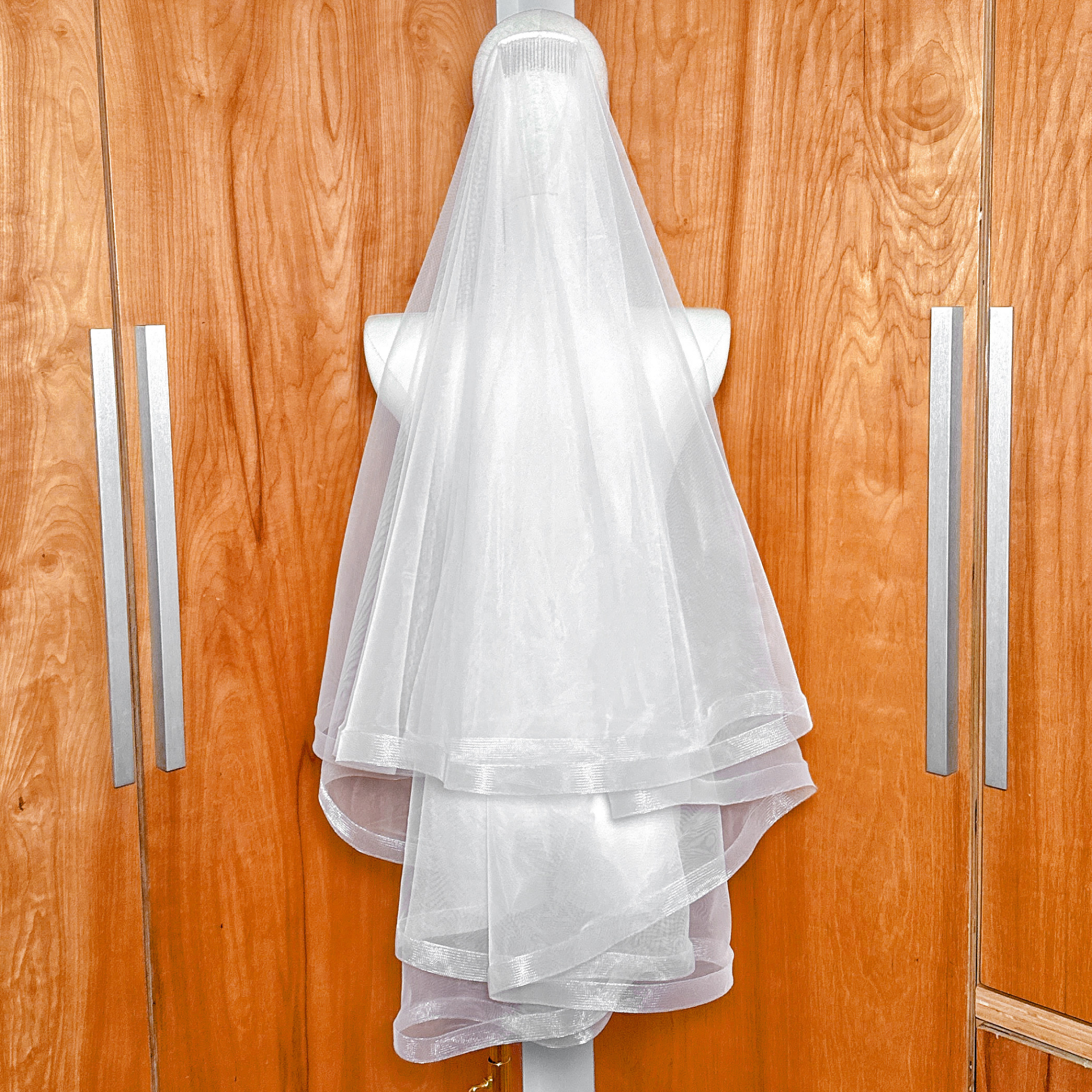 1 1/2" Horsehair Trim Wedding Veil with Blusher in fingertip length displayed on a mannequin.