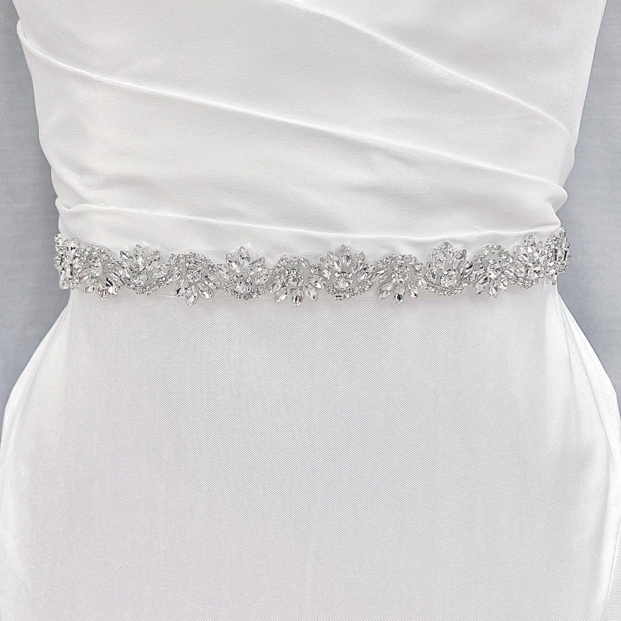 Detailed view of the sparkling embroidery on a silver beaded bridal belt pinned to a bridal mannequin.