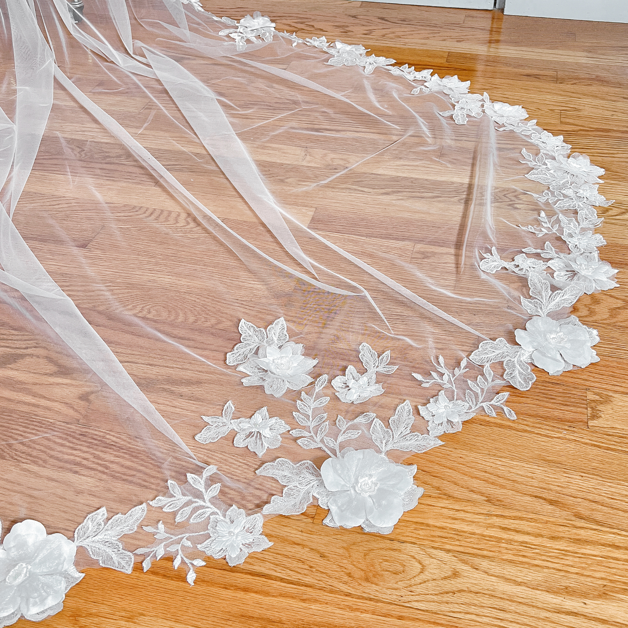 Close-up of the 3D floral lace wedding veil on a mannequin, emphasizing the textured floral embroidery and cathedral-style length.