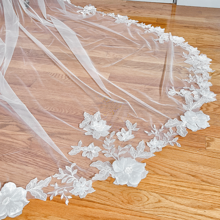 Close-up of the 3D floral lace wedding veil on a mannequin, emphasizing the textured floral embroidery and cathedral-style length.