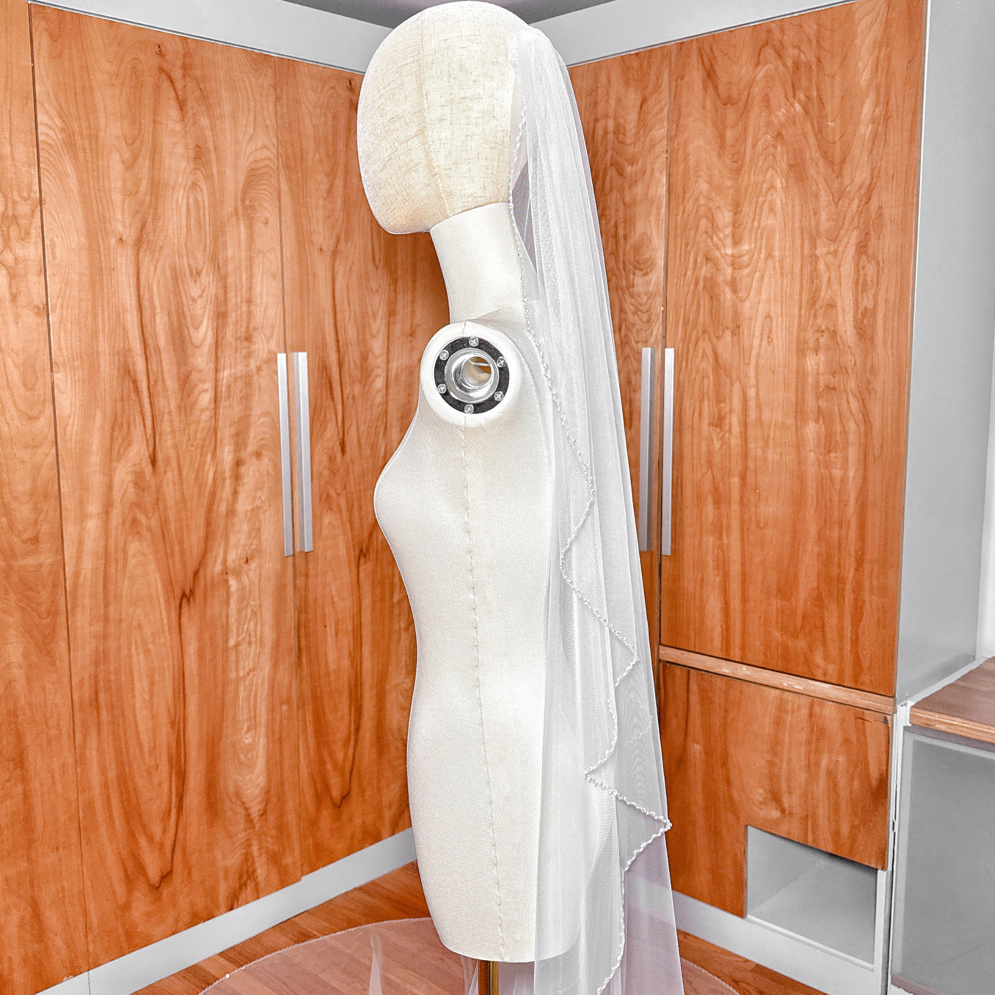 Soft ivory angel cut pearl trim wedding veil in a dramatic cathedral length.