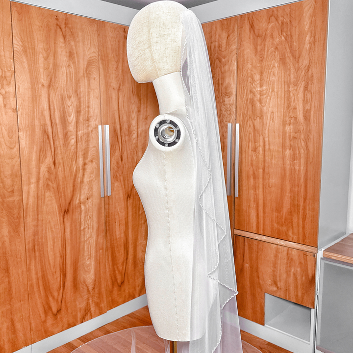 Soft ivory angel cut pearl trim wedding veil in a dramatic cathedral length.