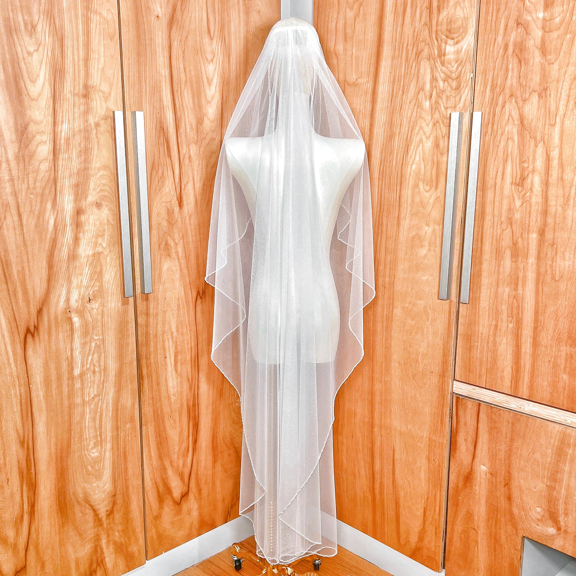 Back view of an ivory angel cut wedding veil in waltz length, showing the soft V-shape taper and pearl-edged finish.