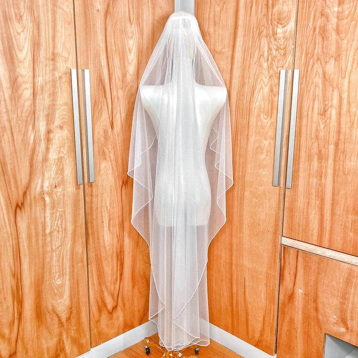 Back view of an ivory angel cut wedding veil in waltz length, showing the soft V-shape taper and pearl-edged finish.