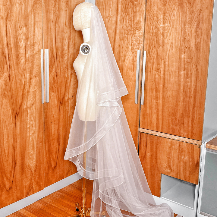 Elegant ivory double horsehair wedding veil in cathedral length shown on a mannequin.