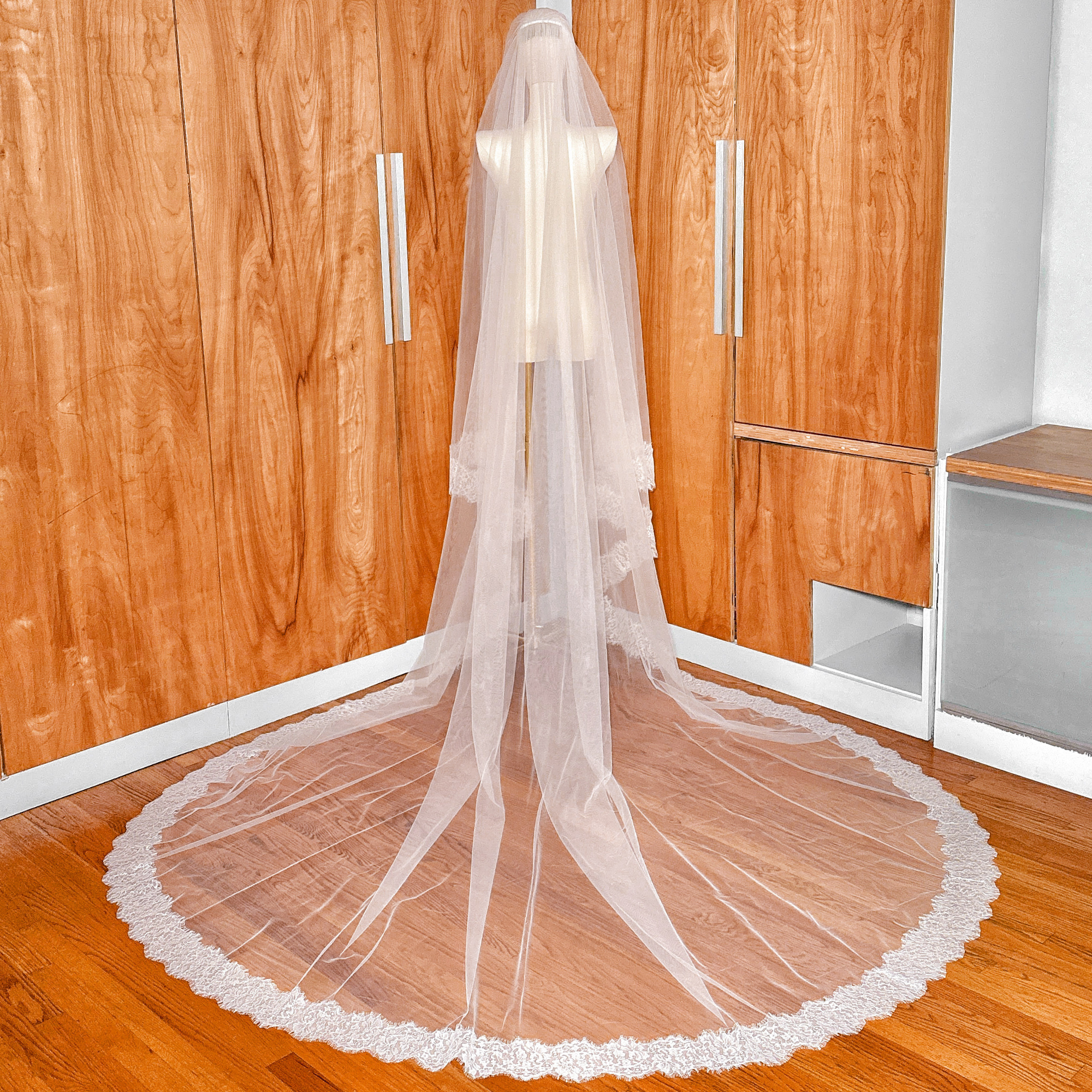 Ivory cathedral length wedding veil with a blusher and delicate Chantilly lace trim.