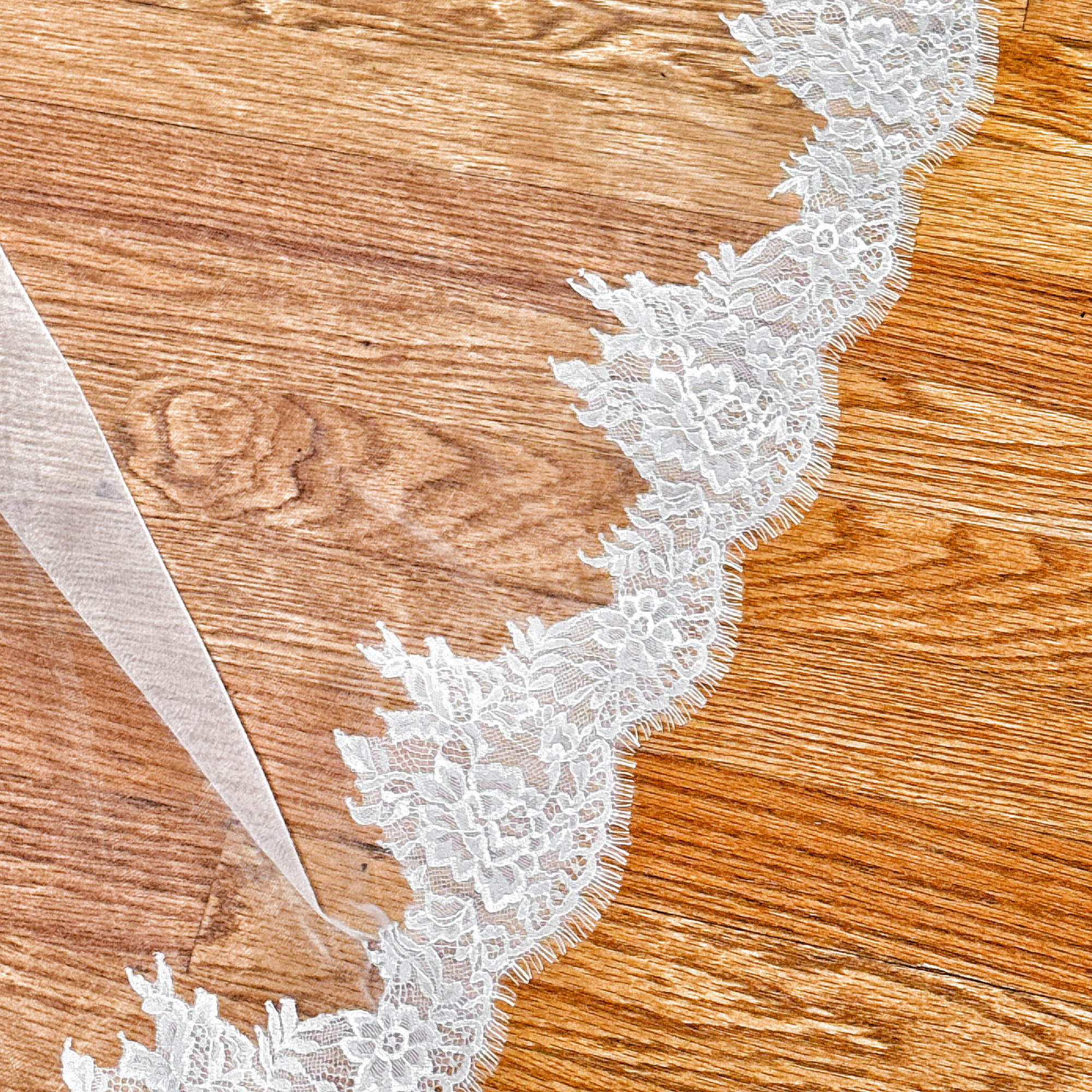 Elegant ivory Chantilly lace cathedral wedding veil showcasing its romantic floral lace pattern.