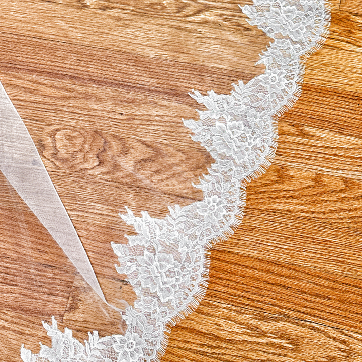 Elegant ivory Chantilly lace cathedral wedding veil showcasing its romantic floral lace pattern.