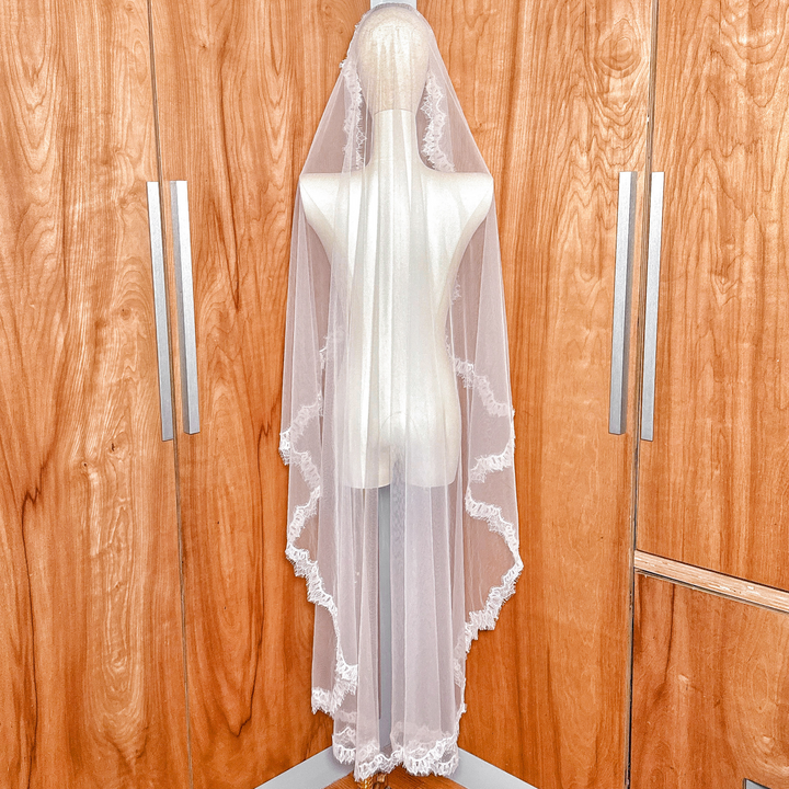 Ivory Chantilly lace mantilla wedding veil in waltz length, showcasing the 60-inch fall from a mannequin's crown.