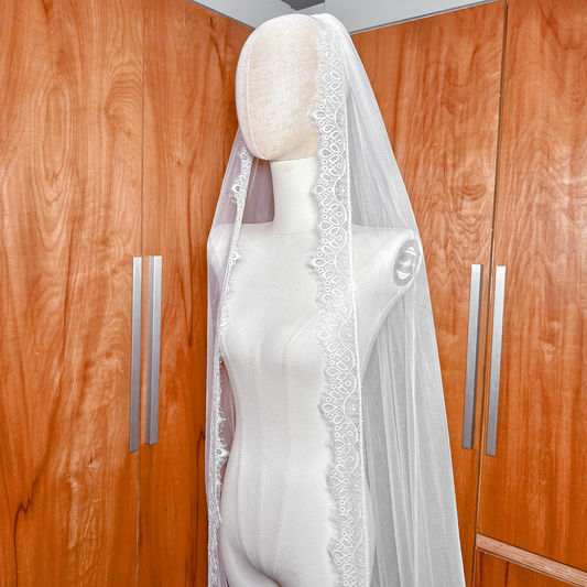 Ivory Chantilly lace wedding veil in a cathedral length shown from behind on a mannequin.