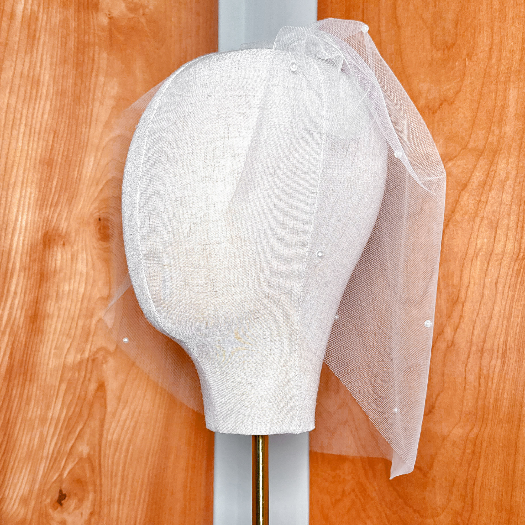 Ivory mesh pearl birdcage wedding veil displaying its vintage blusher style draping.