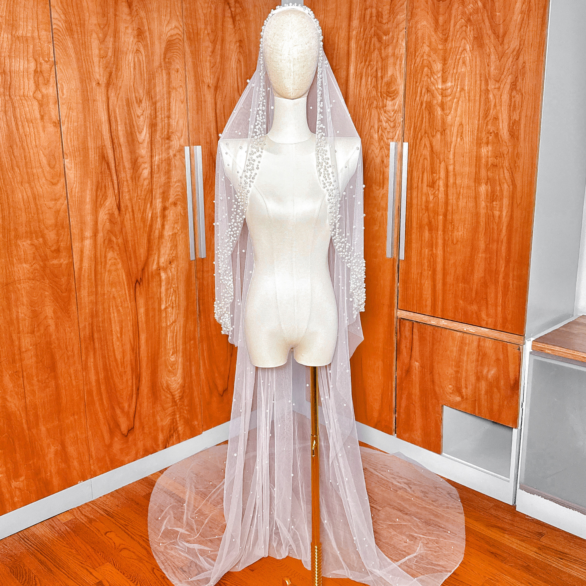 Ivory cathedral length scattered pearl edge mantilla wedding veil showing the sheer tulle and delicate pearl embellishments.
