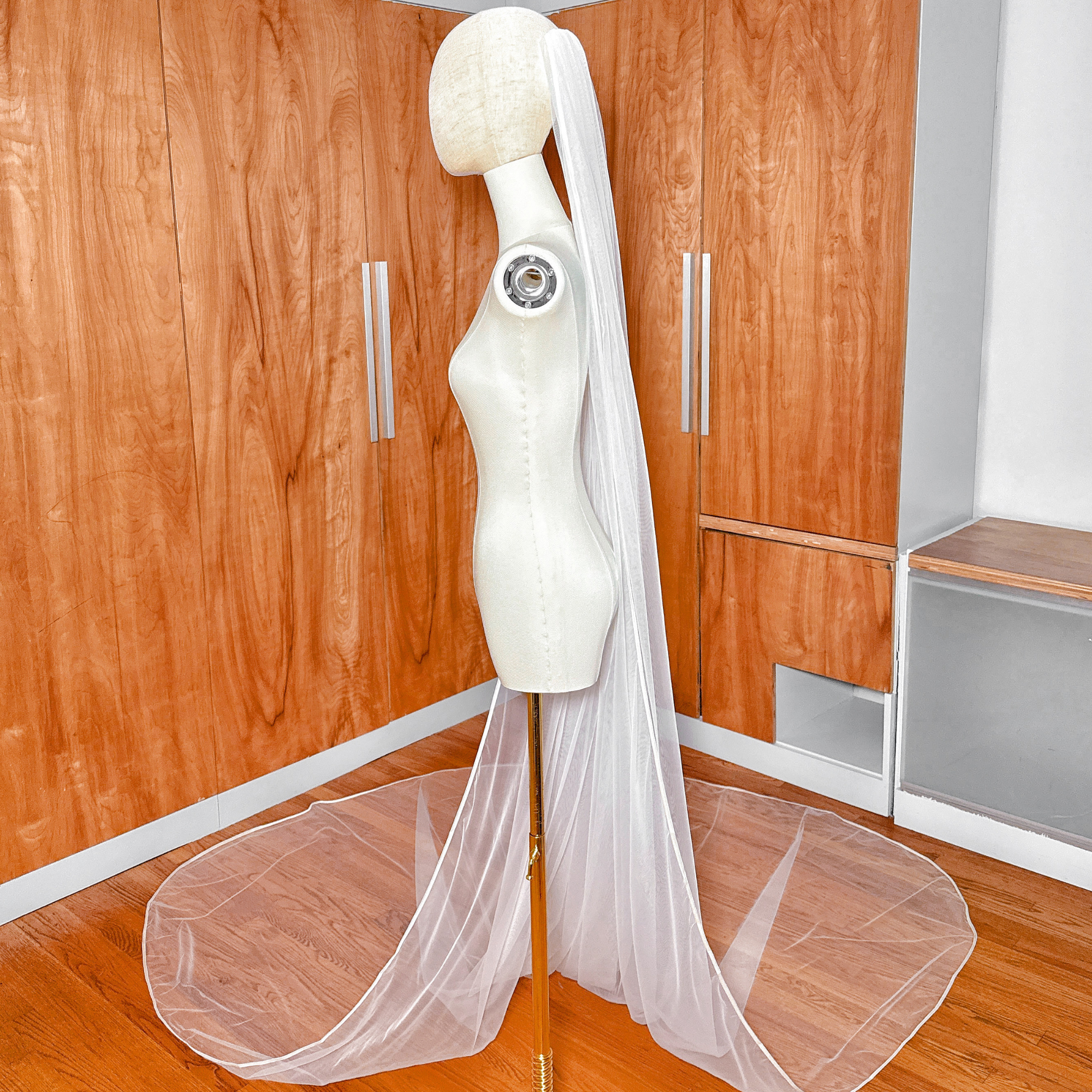 Ivory single tier ribbon edge wedding veil in cathedral length drape.