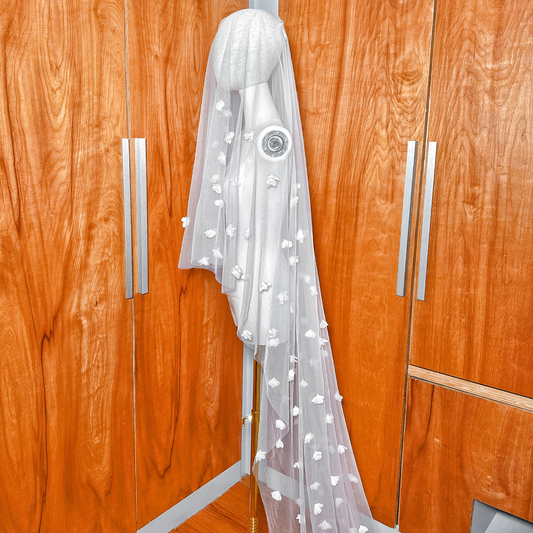 Ivory cathedral length two tier 3D floral wedding veil with blusher draped over a mannequin.