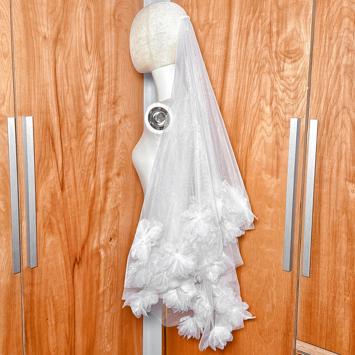 Side profile of a fingertip length two tier 3D flower wedding veil showing the layered volume.