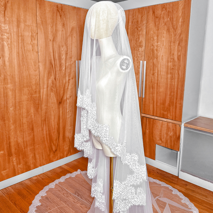 Ivory two tier Chantilly lace trim wedding veil in cathedral length shown on a mannequin.