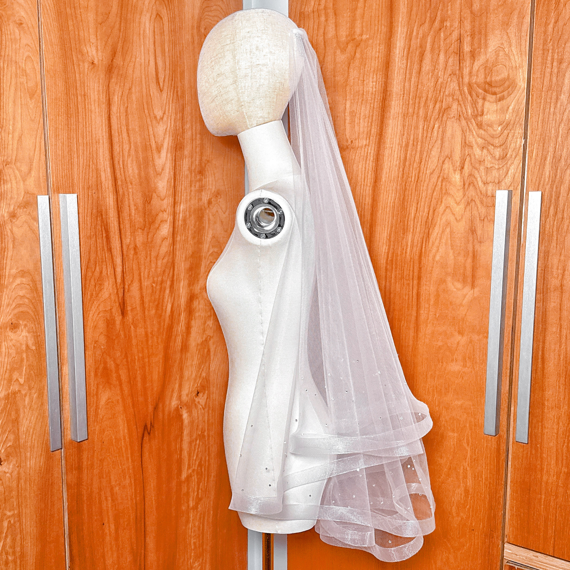 Two tier horsehair wedding veil with scattered rhinestones displayed in fingertip length on a bridal mannequin.