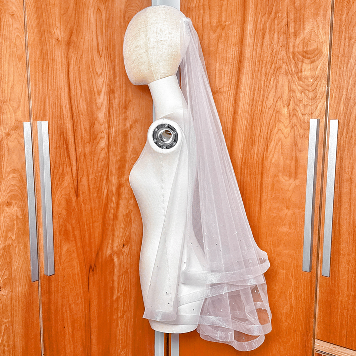 Two tier horsehair wedding veil with scattered rhinestones displayed in fingertip length on a bridal mannequin.