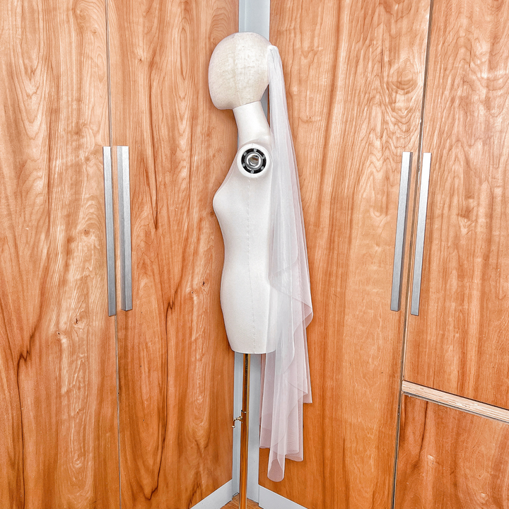 Side profile showing the soft waterfall draping of a knee-length cascade bridal veil.
