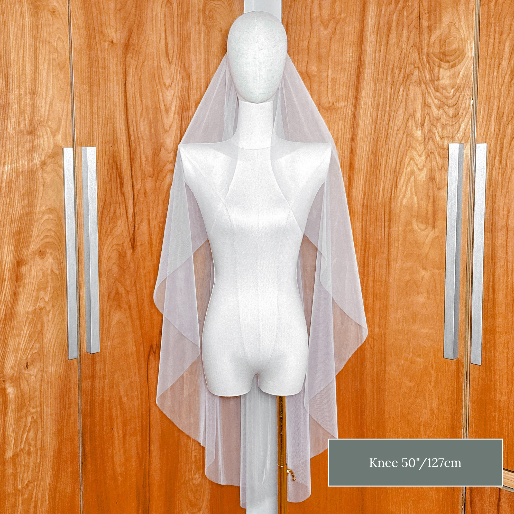 Front view of the clean raw edge finish on a knee length cascade wedding veil.