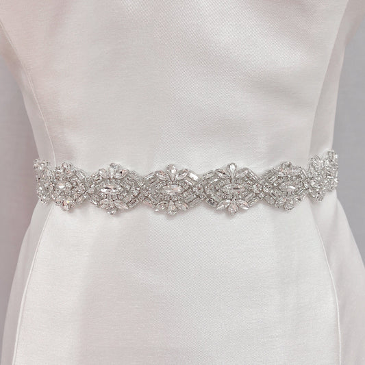 Front view of a luxury Art Deco beaded bridal belt with silver embroidery displayed on a cream fabric mannequin.