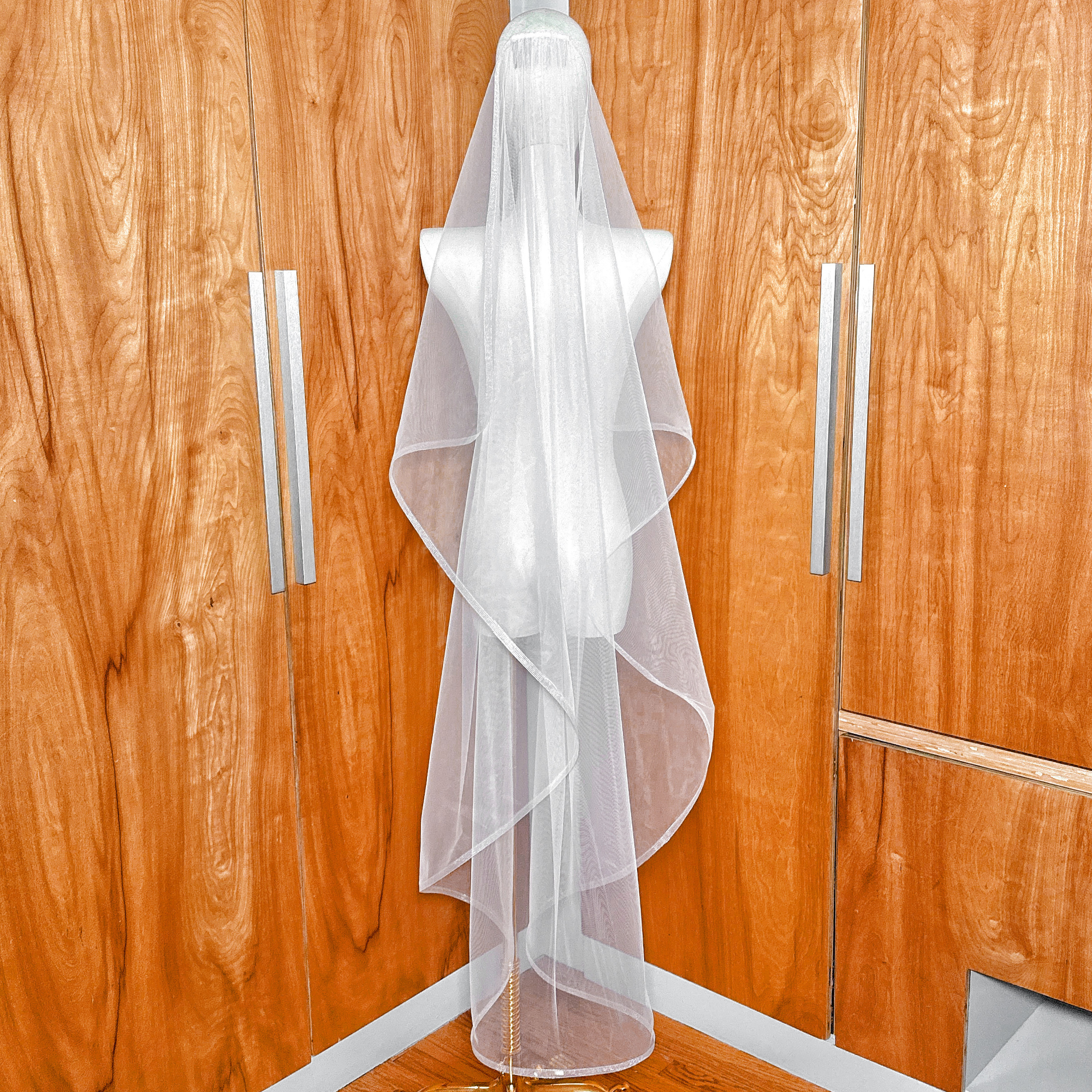 Full-length view of the cascade waltz wedding veil on a mannequin, showing the structured horsehair trim and waterfall silhouette.