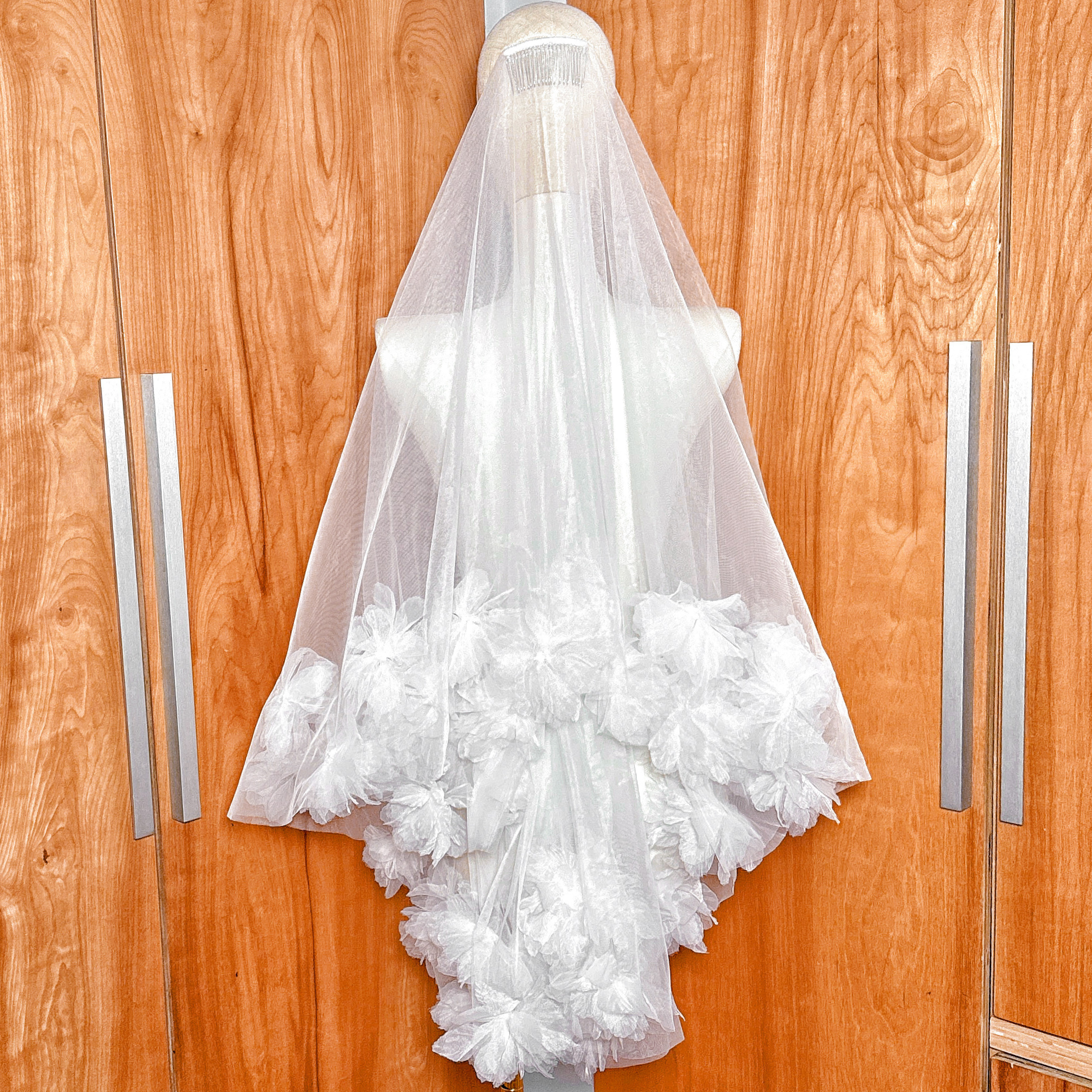 Back view of the two tier 3D flower wedding veil at fingertip length featuring scattered floral details.