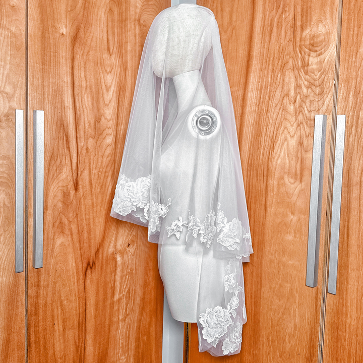 Side profile of a luxury two tier floral lace wedding veil in fingertip length.