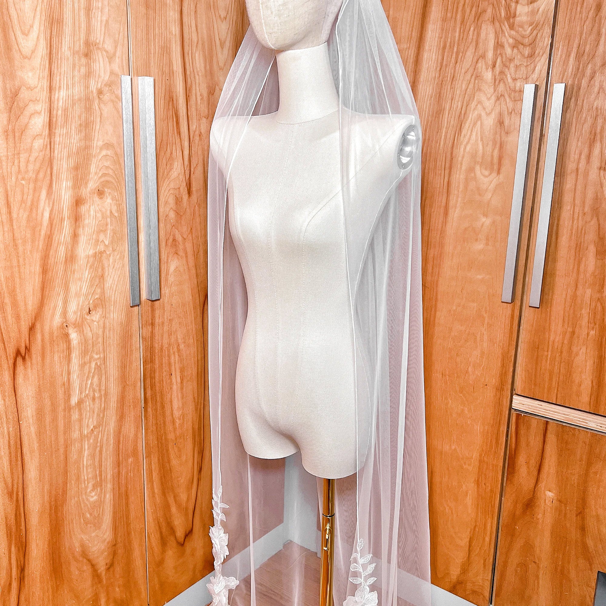 3D floral lace wedding veil in a cathedral cut shown on a professional mannequin to demonstrate the drape and length of the bridal accessory.