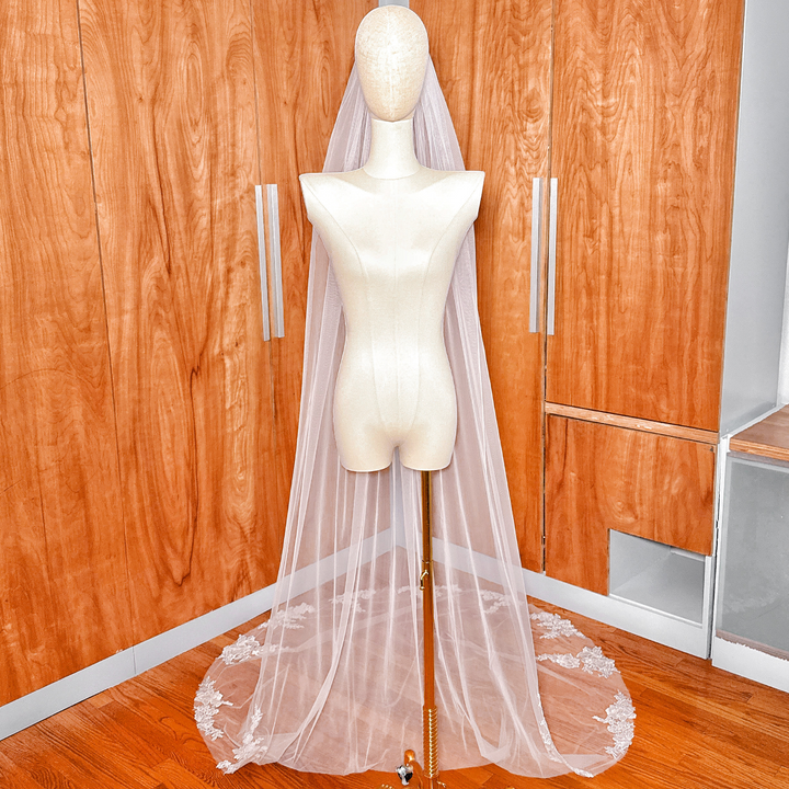 Elegant floral applique wedding veil in cathedral length featured on a dress form mannequin.