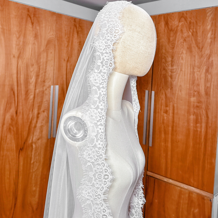 Side profile of a cathedral length Chantilly lace mantilla veil showing the sheer tulle and lace trim.