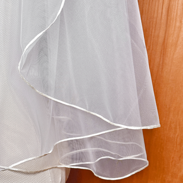Close-up texture detail of the precise micro ribbon trim on an elbow length wedding veil.