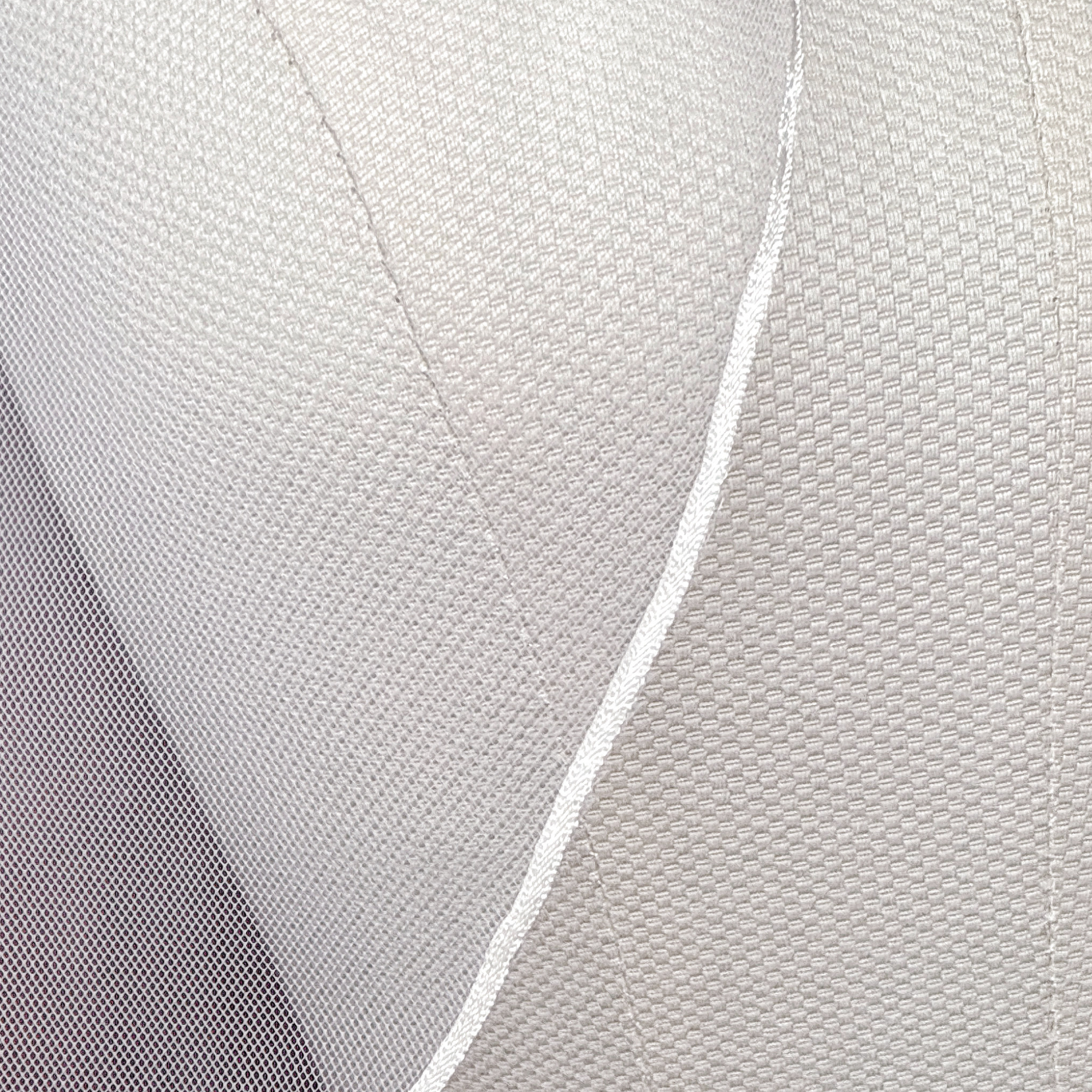 Close-up shot showing the delicate micro ribbon trim on a fingertip length wedding veil.